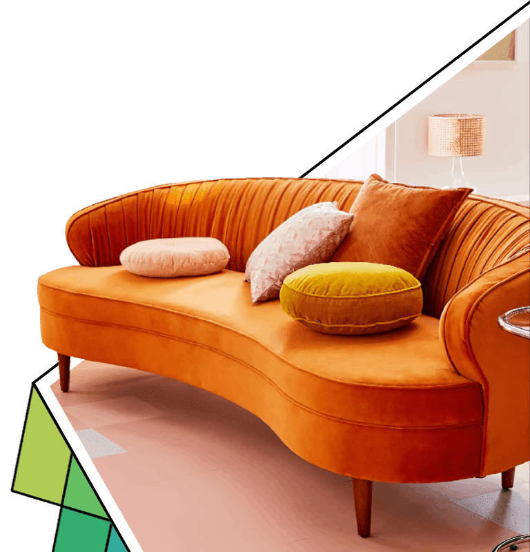 A couch with pillows on it in front of a green wall.