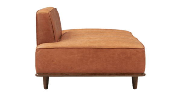 A tan leather sofa with wooden legs.