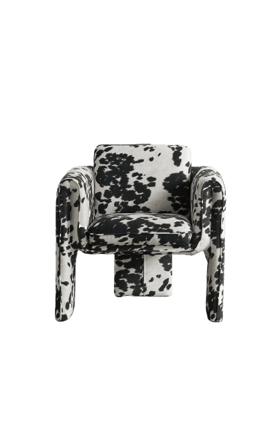 A black and white cow print chair on a green background.