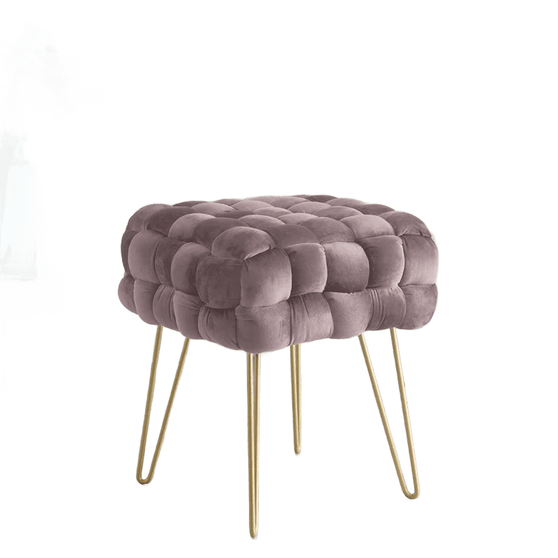 A pink velvet stool with gold legs and a vase.