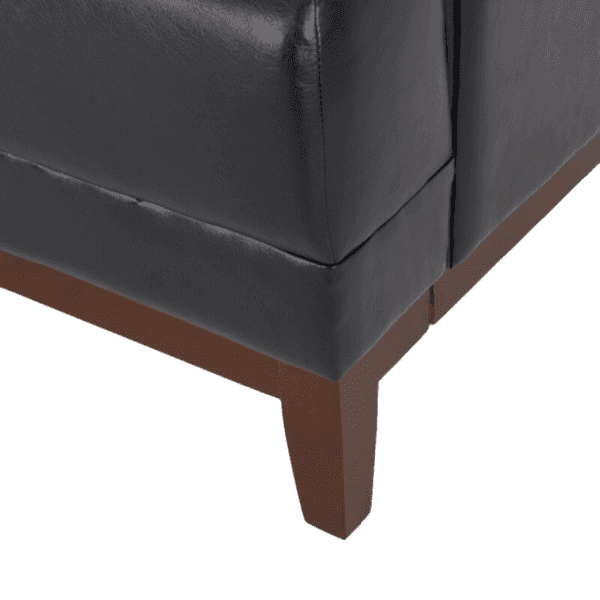 A black leather chair with wooden legs.