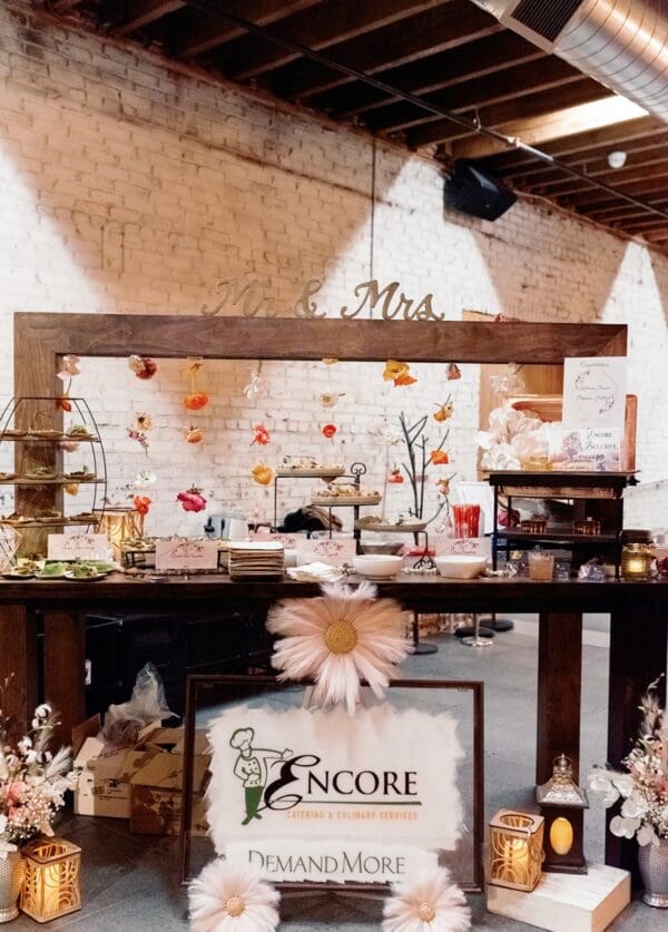 Elegant wedding reception decor with Rustic Kings Table, floral arrangements, and branded signage on display.